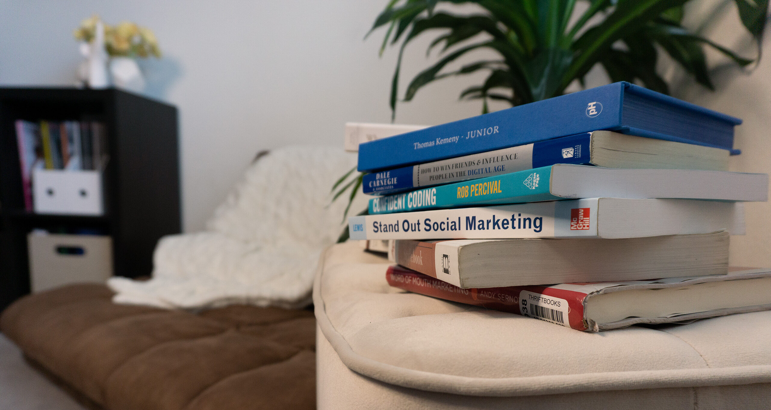 A stack of books in front of a reading nook